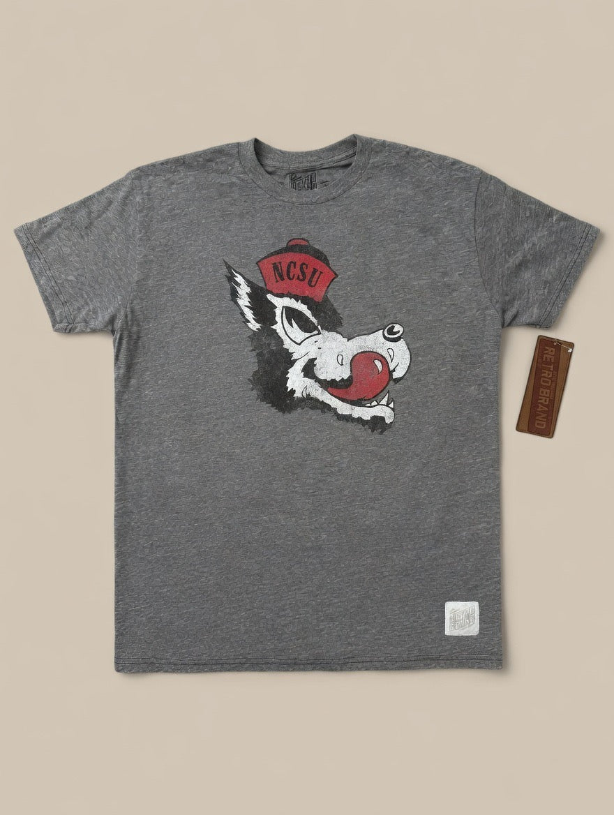 Gray t-shirt with a wolf graphic and 'NC State' logo on a beige background