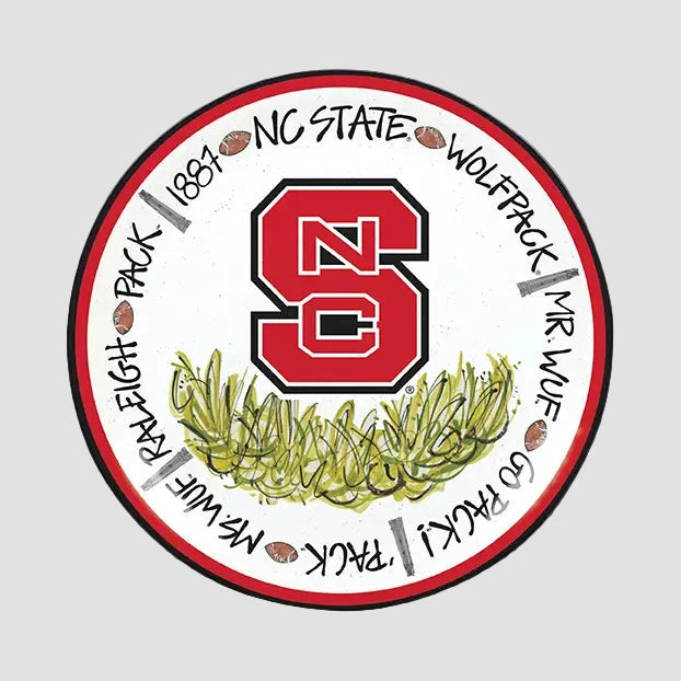 Circular NC State Wolfpack logo with red 'NC' and green leaves plates on a gray background