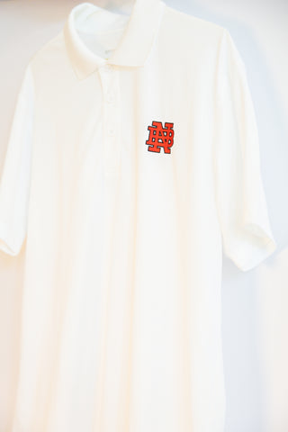 White polo shirt with a red logo for New Bern High School embroidered on it on a white background