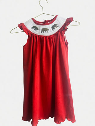 Red smocked dress with white collar featuring bears embroidered it on a white background