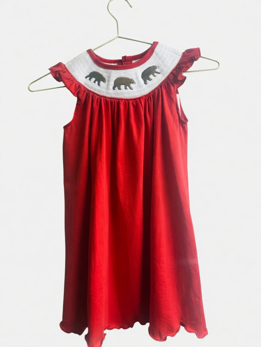 Red smocked dress with white collar featuring bears embroidered it on a white background