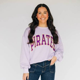 Woman wearing a purple 'PIRATES' crewneck sweatshirt against a white background