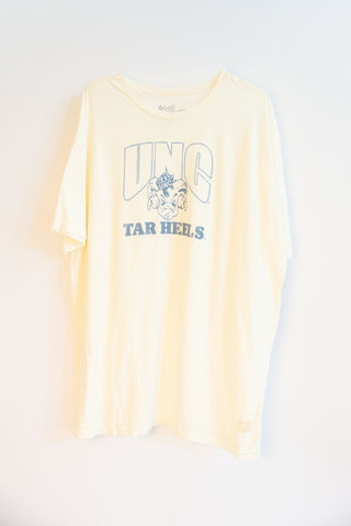 A pale beige short-sleeve t-shirt with a light blue graphic print on the front reading 'UNC TAR HEELS' with a ram mascot logo, displayed against a plain white background.