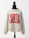 Beige reversible sweatshirt with 'NORTH CAROLINA' printed in red on a mannequin against a white background