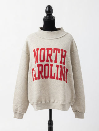 Beige reversible sweatshirt with 'NORTH CAROLINA' printed in red on a mannequin against a white background