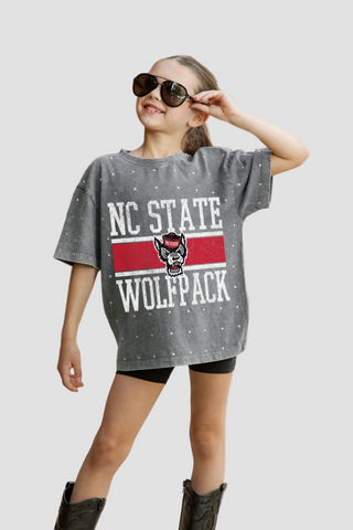 Youth wearing a Rhinestone NC State Wolfpack t-shirt on a sidewalk.