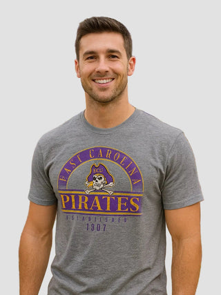 Man wearing a gray 'East Carolina Pirates' t-shirt in front of Dowdy-Ficklen Stadium.