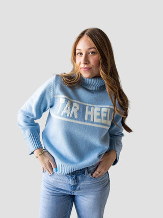 Woman wearing a light blue sweater with 'Tar Heels' text against a white background